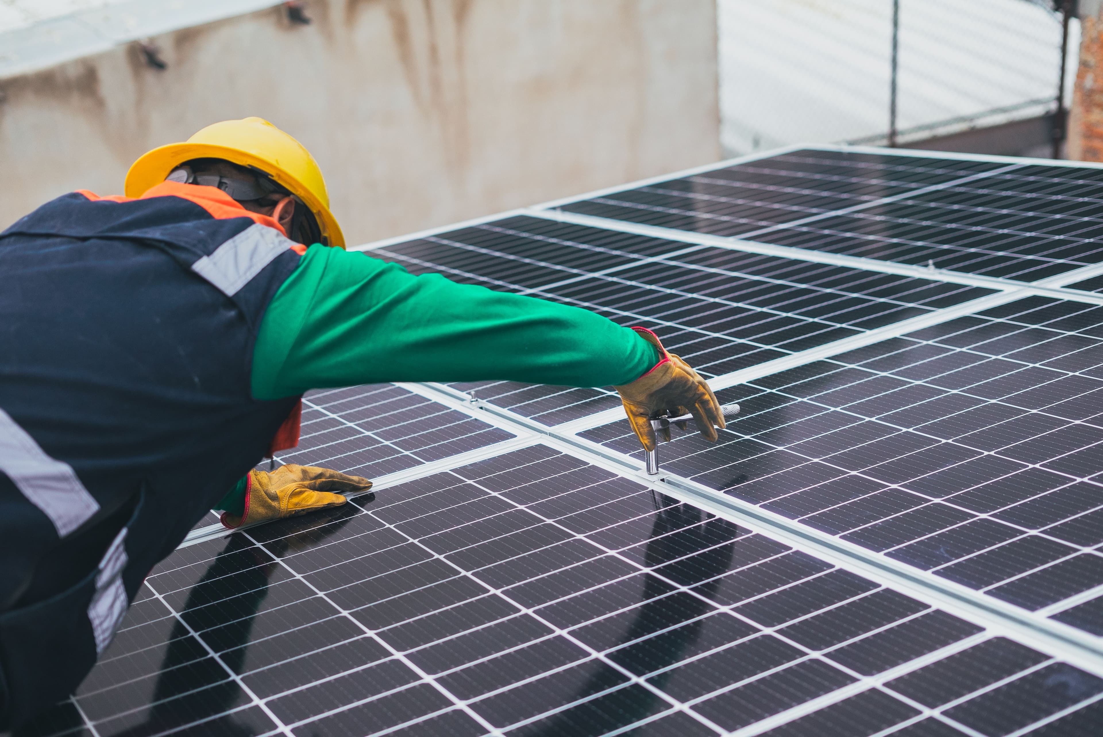 panel solar y trabajador instalandolo